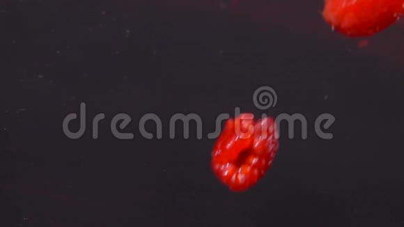 成熟的红树莓会随着美丽的溅落在果汁中视频的预览图