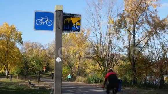 在明尼苏达州明尼阿波利斯沿着哈里特湖的自行车道秋天的下午人们出去锻炼和放松视频的预览图