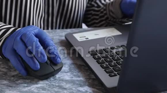 一个年轻的女人戴着手套在家工作隔离自我隔离女孩看一台笔记本电脑免费视频的预览图