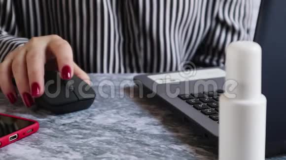 女人在使用笔记本电脑前用防腐剂消毒她的手离家远距离工作社会隔离隔离韩寒视频的预览图