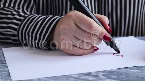中间是一张纸上面有一只雌性手在白纸上写着一条带有红色标记的停止冠状病毒上面显示了它的特写视频的预览图