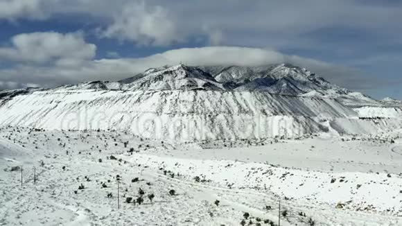 飞越白雪覆盖的白色高海拔山顶斜坡的空中景色视频的预览图
