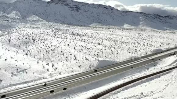 高速公路穿过积雪覆盖的山坡空中侧卡车视野视频的预览图