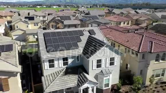 屋顶上有清洁太阳能可再生能源面板的住宅小区住宅上方的鸟瞰图视频的预览图