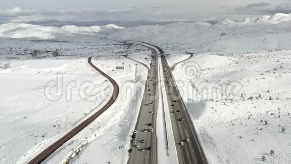 加利福尼亚高速公路穿过积雪覆盖的山坡鸟瞰视频的预览图