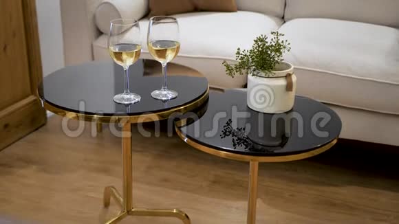 房间里桌子上放着一杯白葡萄酒背景有枕头的沙发约会的浪漫气氛视频的预览图