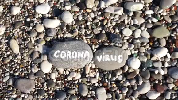海滩上有蓝色大海的石头和冠状病毒视频的预览图