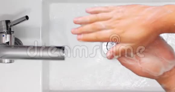 在白色洗手盆上用肥皂洗手的人的俯视图视频的预览图