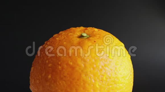 静态的不移动的湿的湿的整个橙色在明亮的橙皮上滴水在黑色的背景上供饮食及食用的水果视频的预览图
