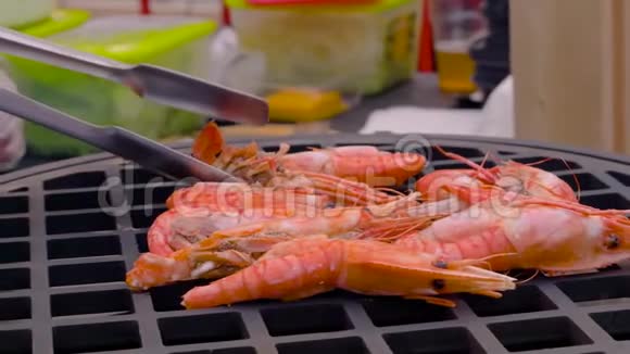 慢动作厨师用热火烧烤炉烤鲜红王虾视频的预览图