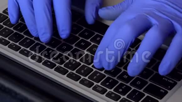 手戴橡胶手套打字在笔记本电脑键盘的角度视频的预览图