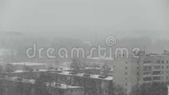 在城市的背景下下雪雪花从灰色的天空落下雪花在前景中飞舞视频的预览图