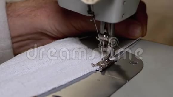 缝纫机裁缝缝一个自制的医用面罩以保护covid19视频的预览图