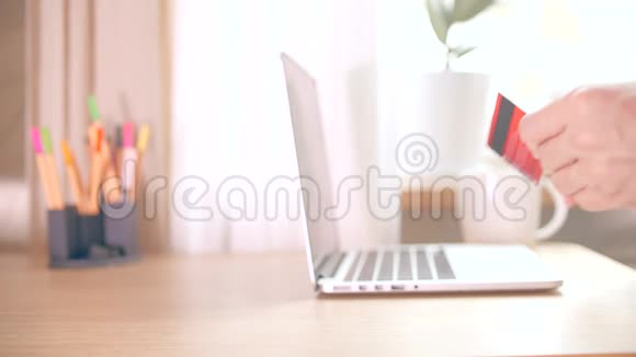 1一个男人用信用卡在家里订购网上商店视频的预览图