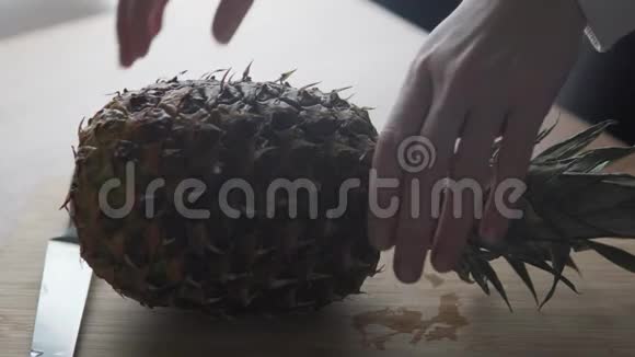 一个大菠萝在厨房里用刀切视频的预览图