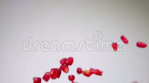 成熟的红粒石榴在白色的背景上飞了下来视频的预览图