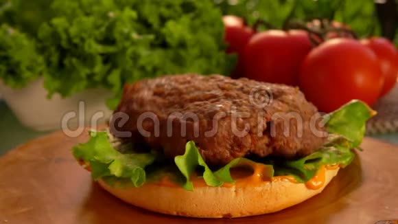 美味的牛肉夹在夹着绿色沙拉的汉堡包上视频的预览图
