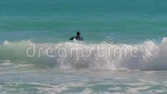 冲浪者躺在海浪上逆流而上视频的预览图