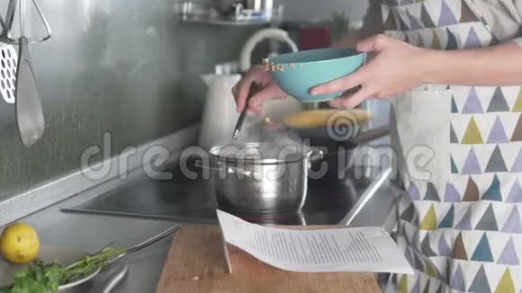 女人根据食谱煮汤视频的预览图