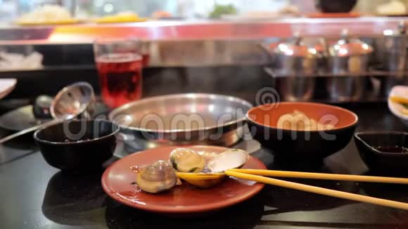 无限的自助餐在一个移动传送带的背景下在盘子里沸腾的贝壳视频的预览图