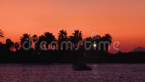 停泊在地中海利帕里群岛棕榈建筑和灯光在黄昏日落五彩缤纷的天空视频的预览图