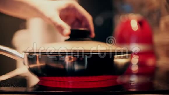 一个人打开热气腾腾的钢制炒锅在家做饭视频的预览图