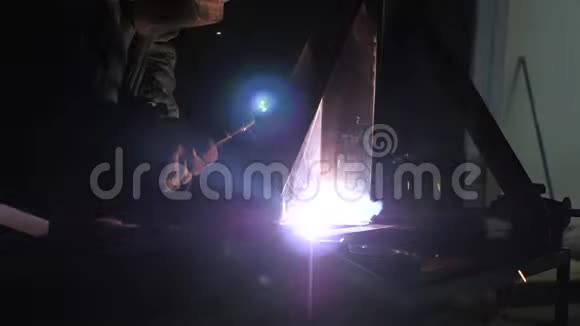 焊接产生的亮光和火花使用现代焊接机焊接防护面罩的工人视频的预览图