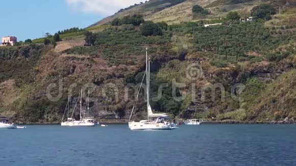 帆船停泊在里帕里岛附近的地中海海域山上有绿树和建筑物蓝天视频的预览图