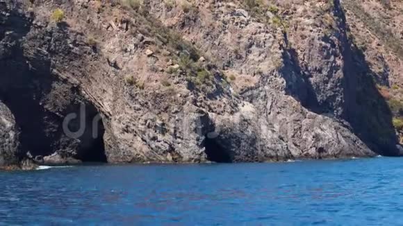里帕里岛地中海有洞穴的山夏日晴天蓝天潺潺的蓝色水面西西里岛视频的预览图