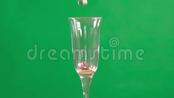 医用药丸倒入香槟杯中置于绿色的关键背景上视频的预览图