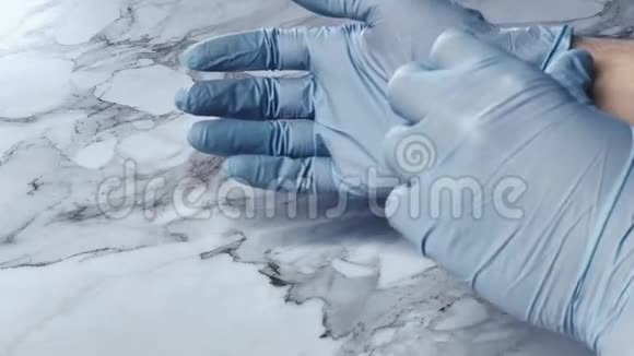 一个人脱下一次性手套COVID19流行性冠状病毒视频的预览图