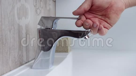 靠近一个男人在浴室水槽上打开水龙头视频的预览图