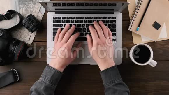 手在笔记本电脑键盘上打字木制桌子俯视图视频的预览图