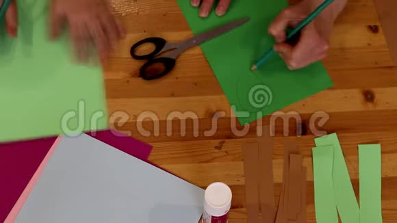 男孩和女孩的手为游戏从纸上剪出数字孩子的教育设计师工作记录视频的预览图