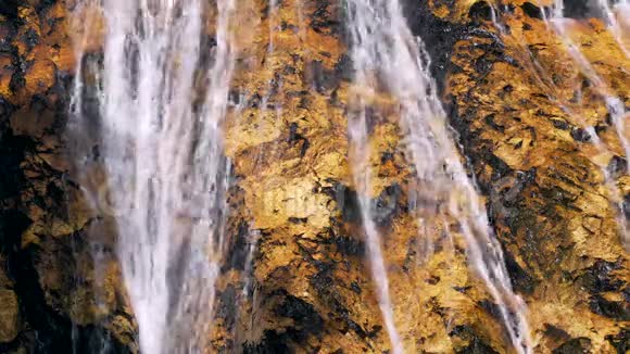 金色瀑布表面的金石和流水的溪流金色的自然背景视频的预览图
