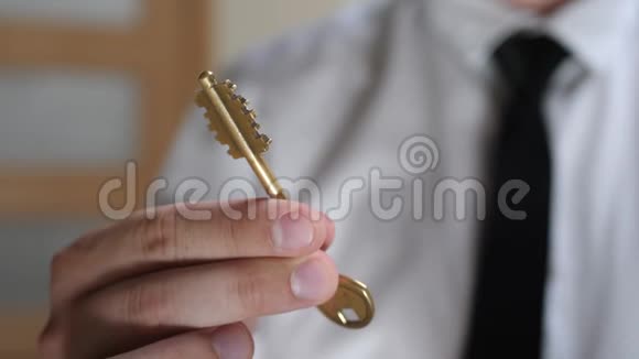 男人的手握着金色的家钥匙视频的预览图