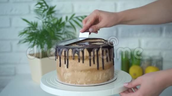 一位女糕点厨师从糕点袋中装饰蛋糕涂上巧克力奶油视频的预览图