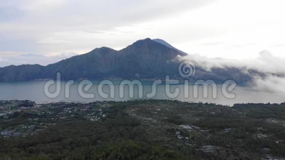 从印度尼西亚巴厘岛巴图尔金塔马尼火山顶部日出时可以看到云和雾的风景视频的预览图