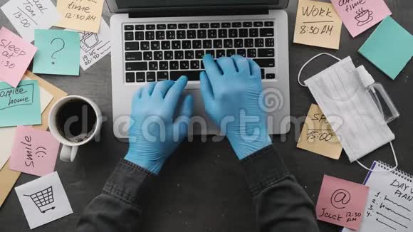 他在家里戴着医用手套的笔记本电脑工作他注意到工作场所到处都是视频的预览图