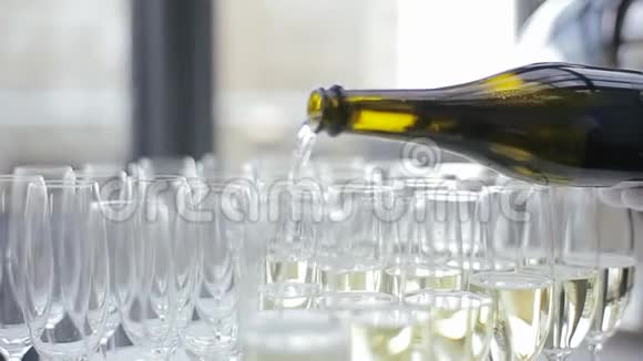 一瓶香槟装满了一个空杯子里的液体在优雅的香槟酒杯中酒沫沫沫站在一个视频的预览图