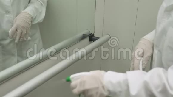 女士使用湿擦和酒精消毒喷雾清洁电梯中的栏杆消毒清洁和卫生视频的预览图