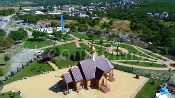 在阳光明媚的日子里在格伦德日克市入口处的一个木制东正教小教堂里飞来飞去视频的预览图