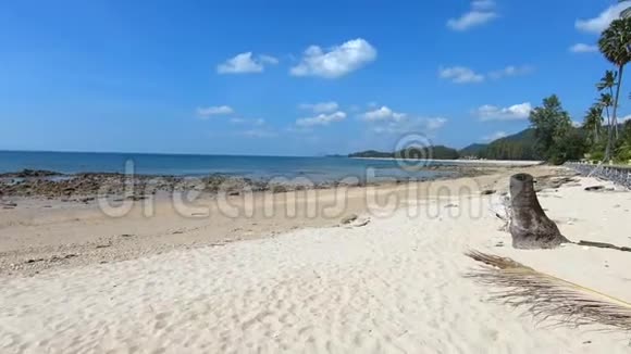 在泰国克拉比科兰塔岛白色沙滩上棕榈树下的海滩上散步小波浪视频的预览图