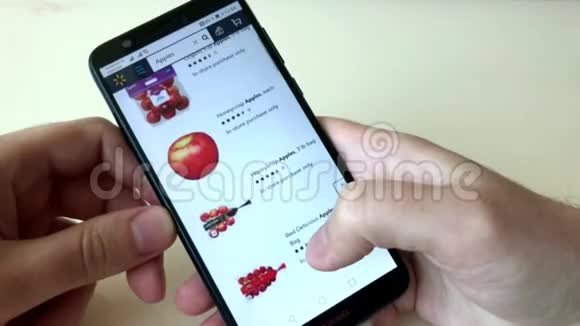 一个男人用智能手机在网上商店订购苹果在网上商店选择带家庭送货的产品视频的预览图
