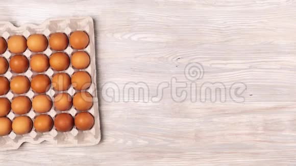 纸板箱里的鸡蛋消失在木制背景上视频的预览图