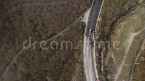 几辆车在山区狭窄的公路上行驶鸟瞰视频的预览图