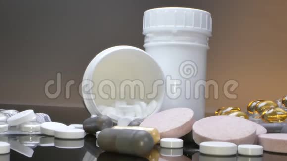 治疗理念药包罐子和药片散落在黑桌上视频的预览图