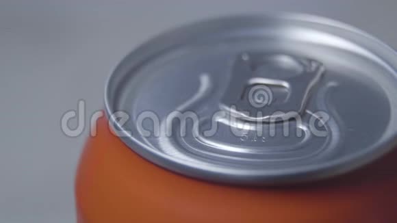 关闭橙色罐顶部的特写带有碳酸软饮料或酒精的金属容器饮料液体视频的预览图