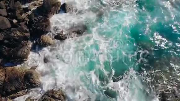 青绿色的海溅在海岸的悬崖上视频的预览图