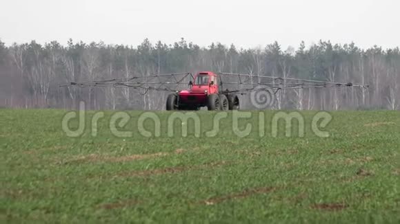 农民在一个自行式喷雾器过程中上升冬季作物在农田视频的预览图